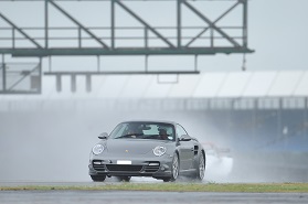 Silver Porsche on wet racing circuit